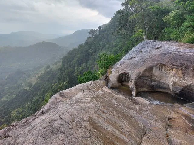 Rock pools on the lip of Upper Diyaluma Falls above a forested valley