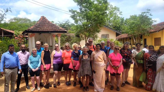 A cycling group with teachers in saris during a visit to a village school