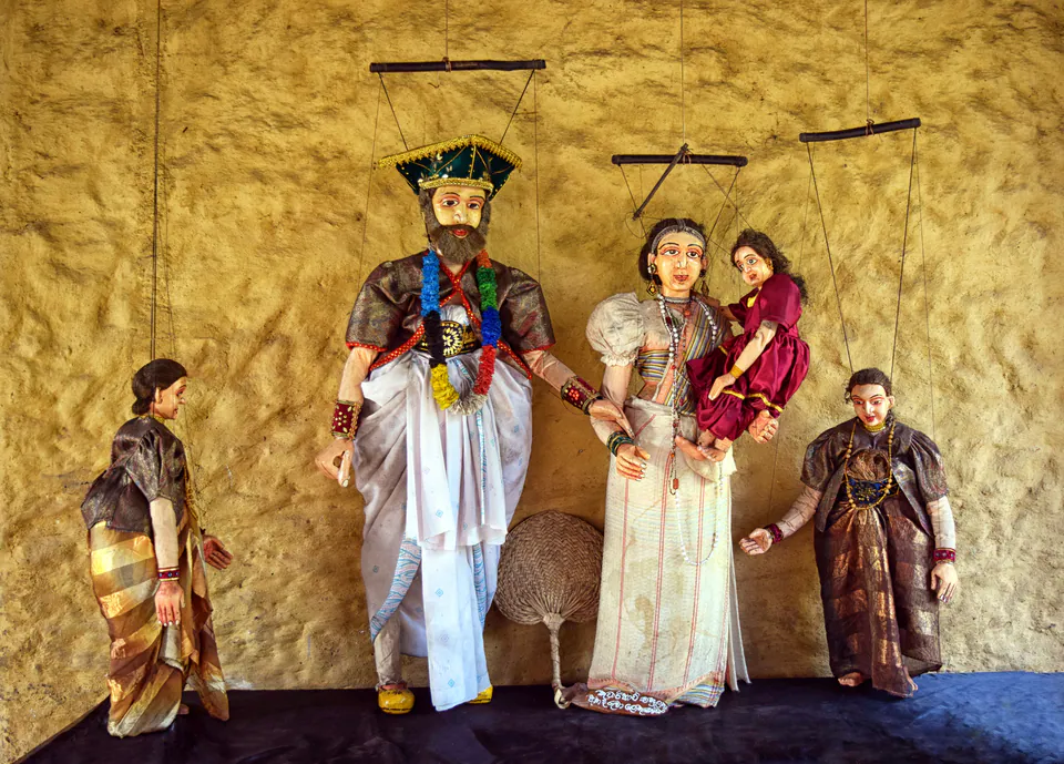 Traditional string puppets of a noble family hanging against an ochre wall