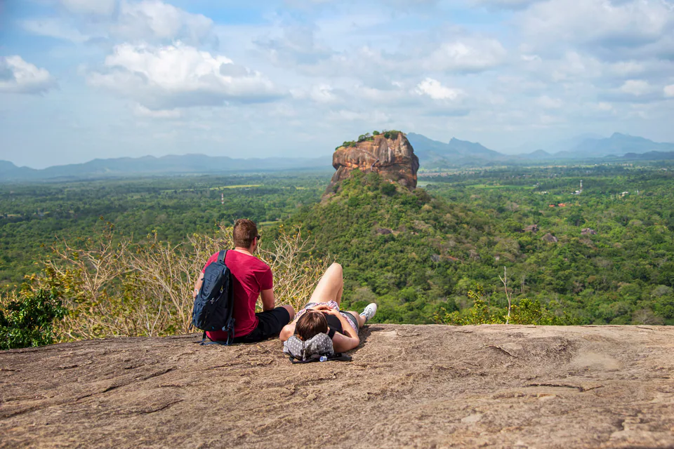 Two travellers resting on the summit of Pidurangala, gazing across the forest to Sigiriya rock