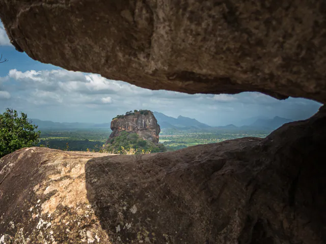 Sigiriya rock framed through a gap between dark boulders