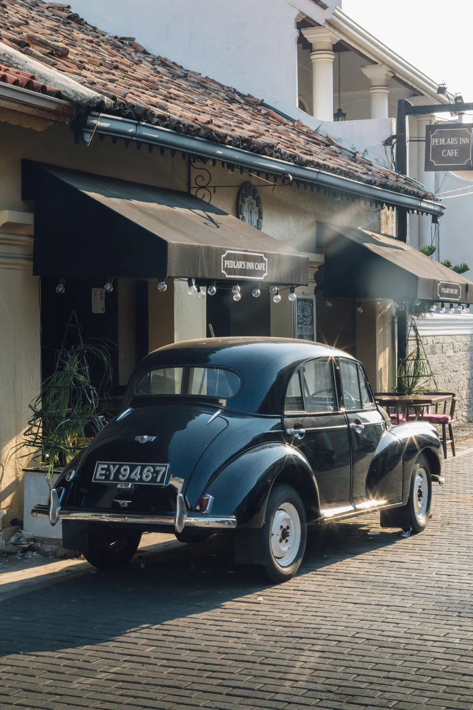 A vintage black Morris Minor parked outside a café in Galle Fort