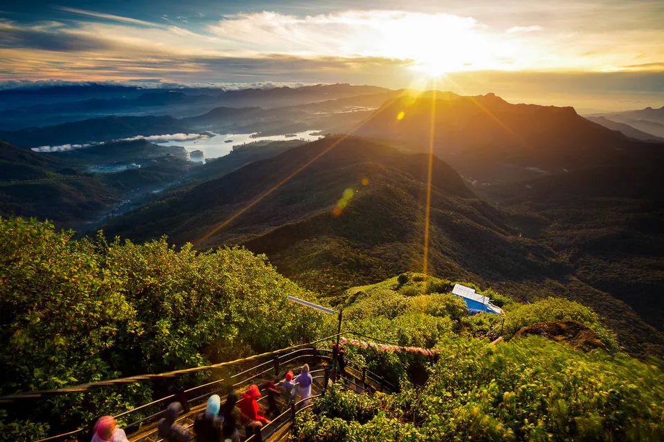 Sunrise from the summit of Adam’s Peak over misty ridges and the Maskeliya reservoir