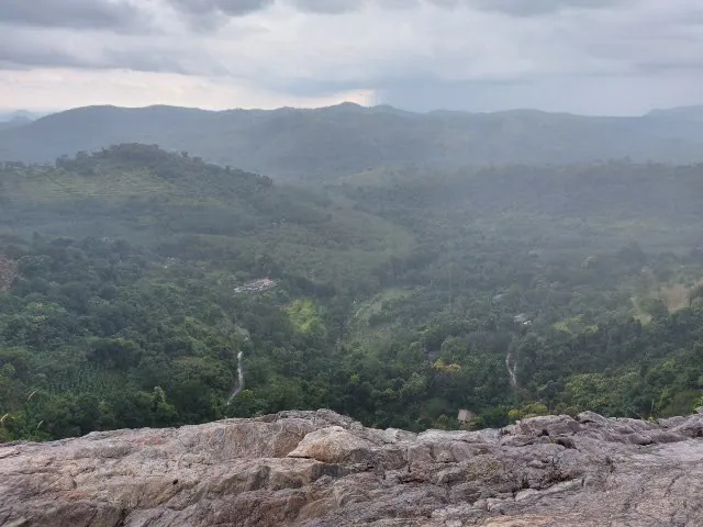 The view from the granite slab at the top of Diyaluma Falls over a misty forested valley